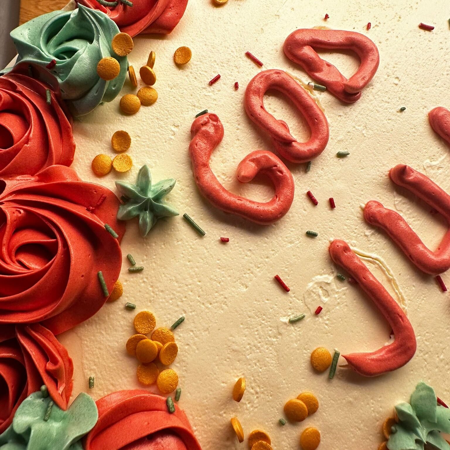 Et utvalg fargerike cupcakes utstilt på pastellfargede fat. Cupcakene er pyntet med rosa og hvit krem, dryss i ulike farger og sjokoladebiter. Noen har mørk sjokoladekakebunn, andre lys vaniljebunn.